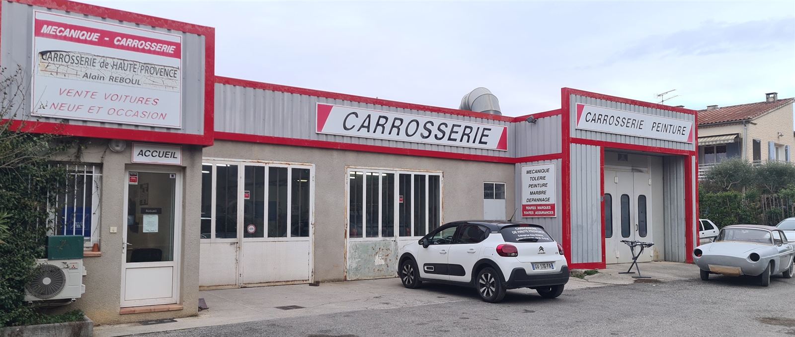 Façade de l’atelier Carrosserie de Haute-Provence à Oraison, enseigne rouge et porte d’accueil