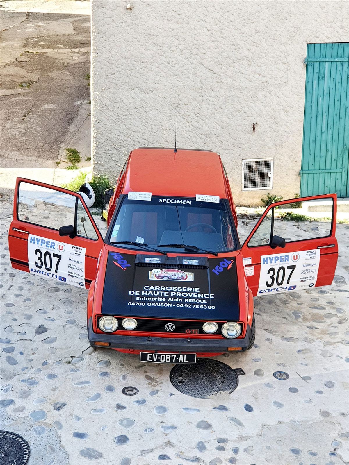 Voiture de rallye aux portières ouvertes, numéro de course sur les portières