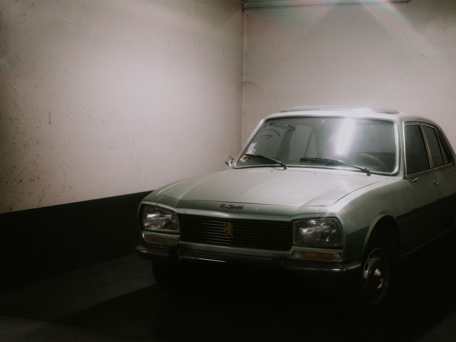Berline ancienne grise garée dans un garage